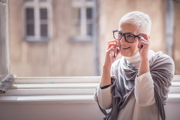 Older woman wearing glasses, talking on phone